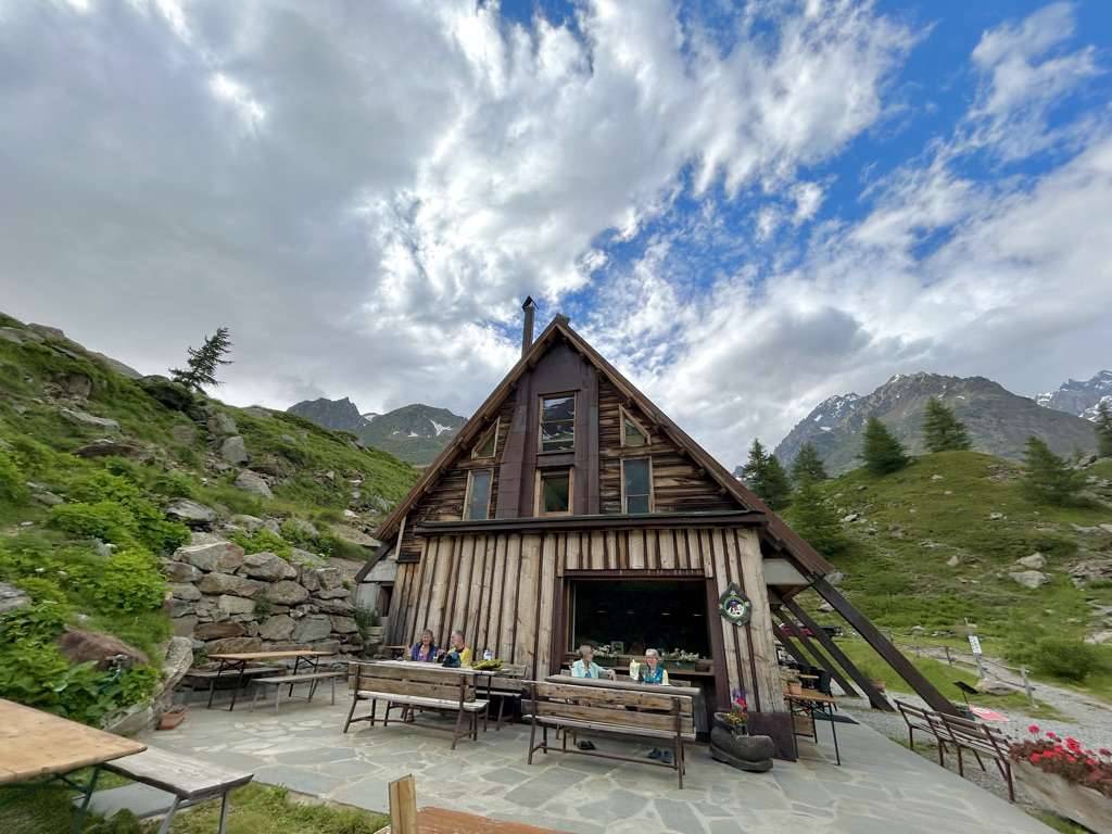 Hikers enjoy sitting outside Cabane du Combal