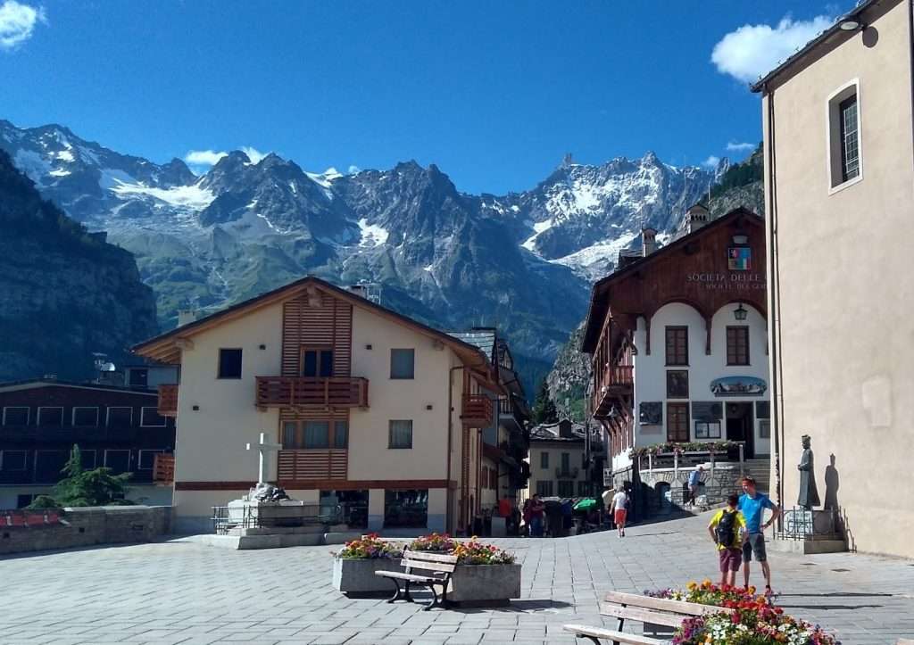 A plaza with building and mountains in the background in Courmayeur, Italy.