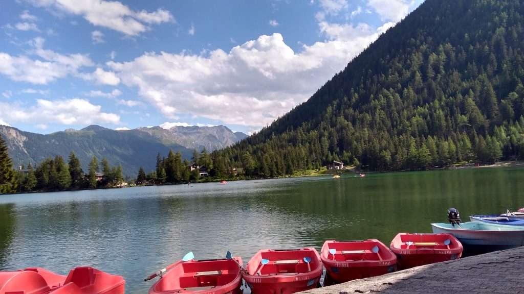 Red paddle boats docked on the shore of Champex-Lac.