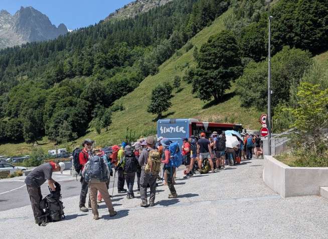 TMB hikers wait in line for the Le Tour bus.